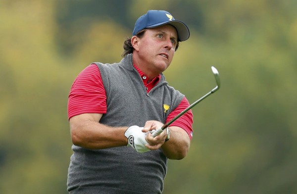 U.S. Team player Phil Mickelson hits an iron on the 10th fairway during the second practice round for the 2013 Presidents Cup golf tournament at Muirfield Village Golf Club in Dublin, Ohio